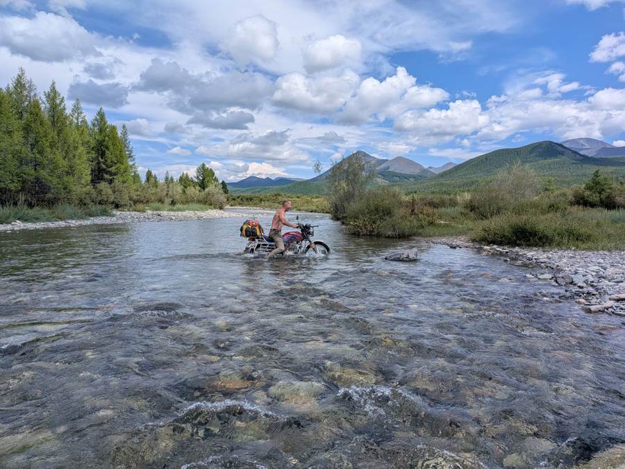 Walking a loaded bike through a river, Mongolia 2026